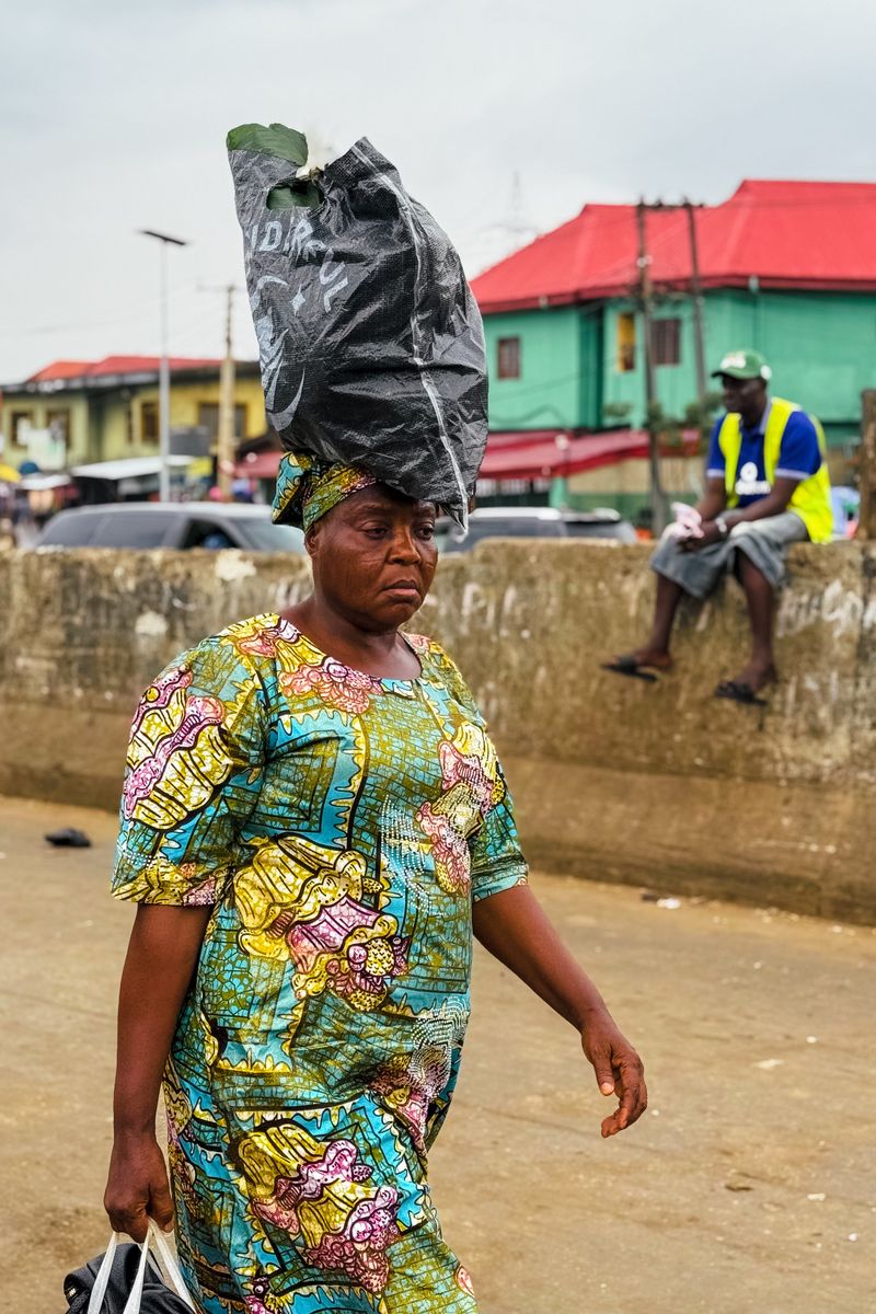 A trader walking through a busy Lagos market